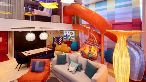 Kids playroom with a slide and game tables